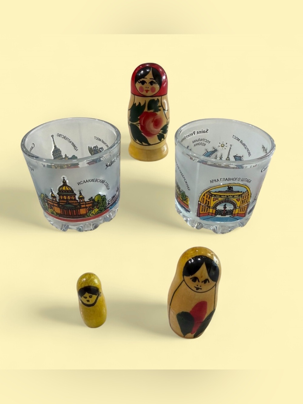 Set of 2 glass shot glasses with wooden matryoshka dolls.